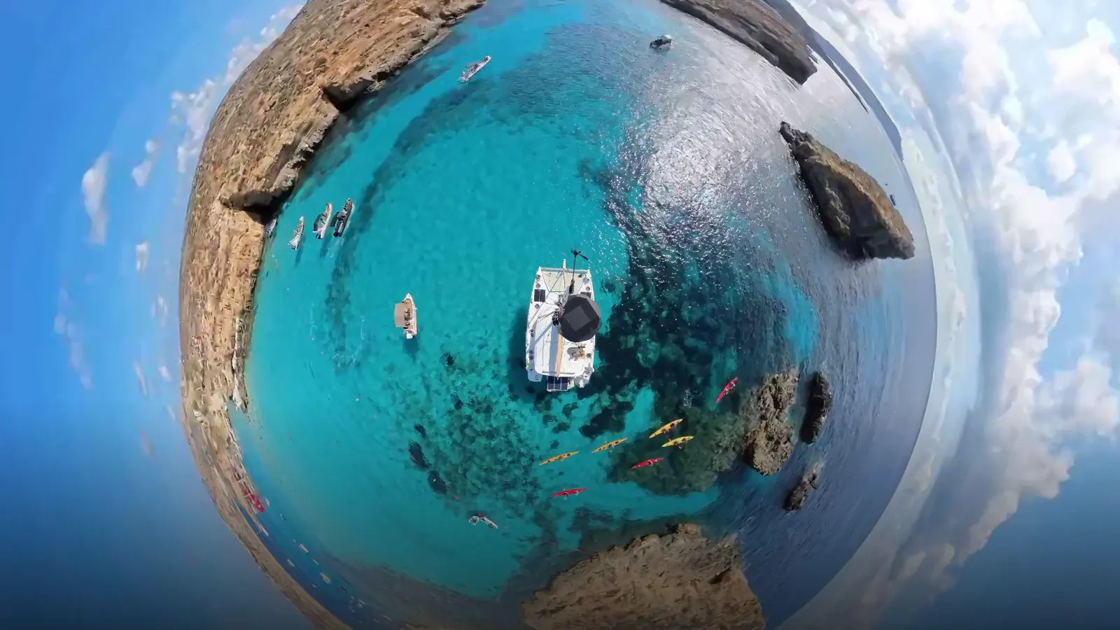Colour 360 degree frame of a catamaran at anchor in Blue Lagoon, with kayaks and tenders around it