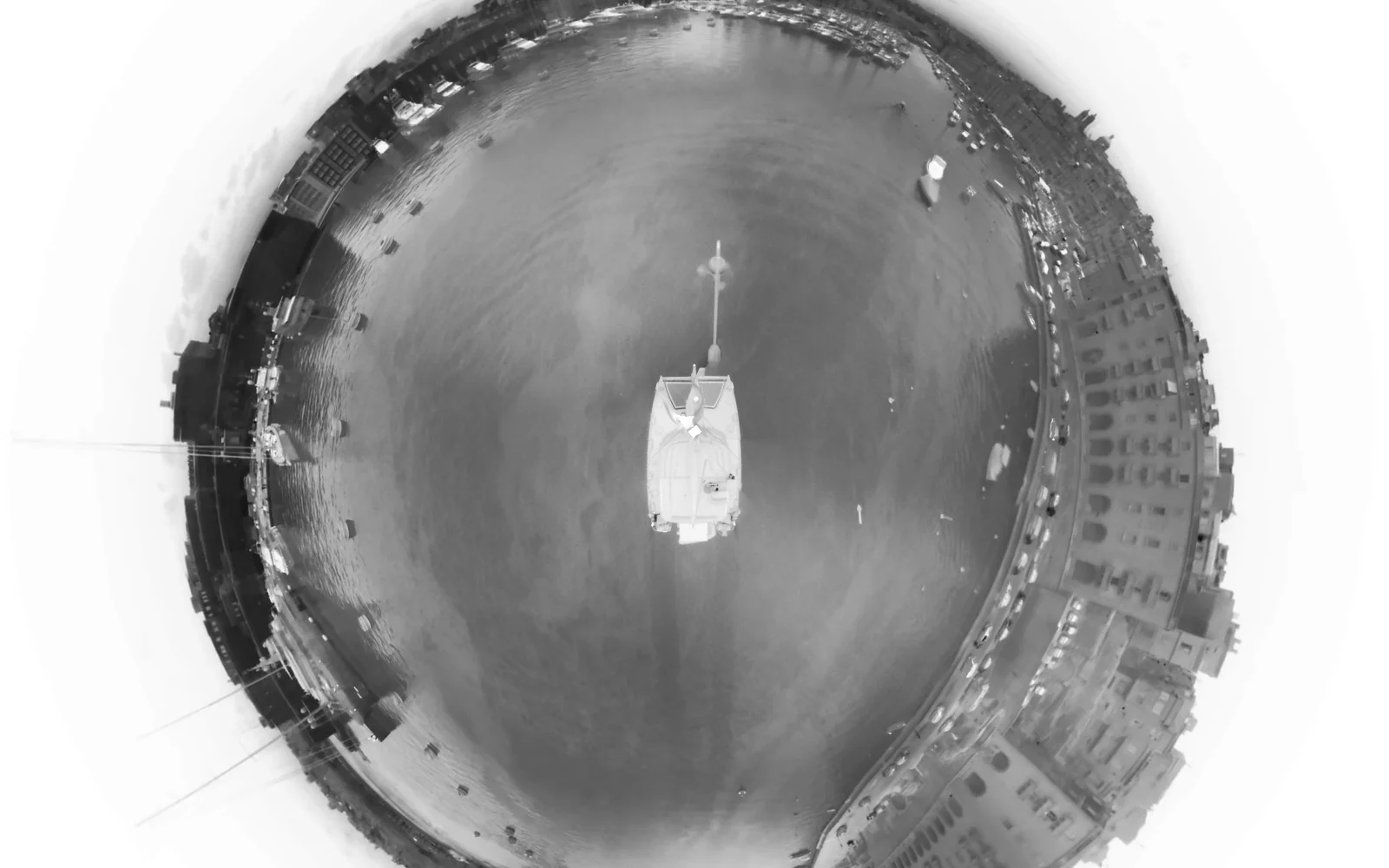 Thermal infrared 360° panorama of a harbour at dusk, moored boats and waterfront buildings in the iron colour palette.